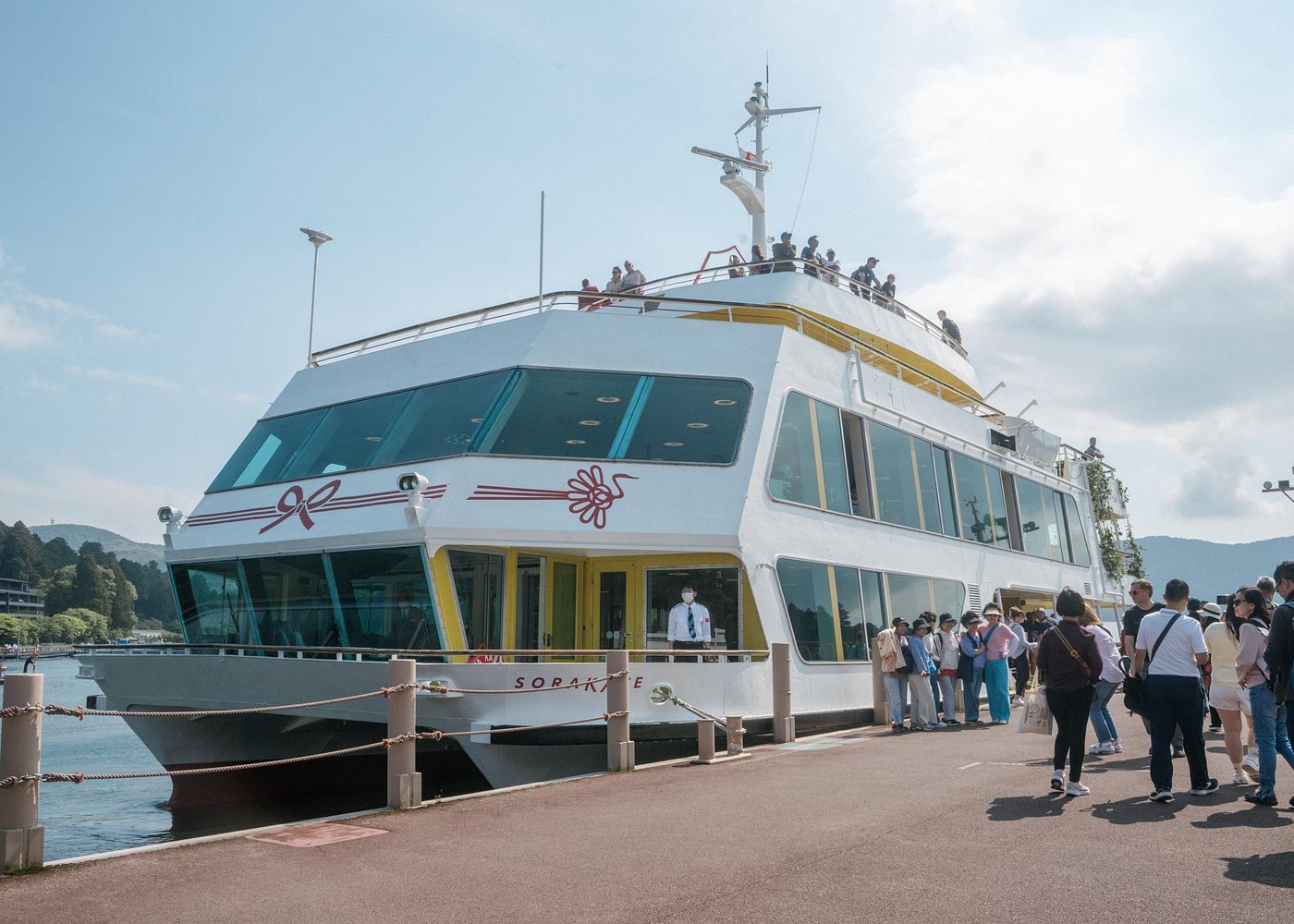 Travelers boarding the white SORAKAME sightseeing boat at the Lake Ashi pier